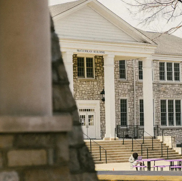 The front of the McClurkan Building with a student working out front